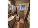 Bathroom featuring a white vanity, neutral walls, and wood-look flooring at 1623 S Grant Ave, Indianapolis, IN 46203