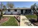 Quaint, white-brick home featuring manicured lawn, mature trees, and a covered porch entry at 1623 S Grant Ave, Indianapolis, IN 46203