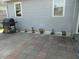 Back patio with charcoal grill, wood storage, and row of colorful plants at 1722 N Parker Ave, Indianapolis, IN 46218