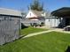 A backyard boasts a patio with a fire pit, seating, and an umbrella, with a grass yard and fencing at 1722 N Parker Ave, Indianapolis, IN 46218