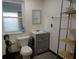 Compact bathroom with a sink, toilet, storage shelves and a window providing natural light at 1722 N Parker Ave, Indianapolis, IN 46218