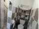Clean and practical bathroom featuring a toilet, shower stall, and a shelving unit for storage at 1722 N Parker Ave, Indianapolis, IN 46218
