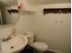 Functional bathroom featuring a sink, toilet, and practical storage shelves at 1722 N Parker Ave, Indianapolis, IN 46218