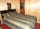 Cozy bedroom featuring a bed with striped bedding and wood-paneled walls at 1722 N Parker Ave, Indianapolis, IN 46218