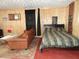 Bedroom featuring wood paneling, a sofa, and a bed with striped bedding at 1722 N Parker Ave, Indianapolis, IN 46218