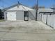 View of the exterior of a building showing a garage, door, and gravel for parking at 1722 N Parker Ave, Indianapolis, IN 46218