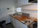 Cozy kitchen featuring wooden countertops, a stainless steel sink, and white cabinets at 1722 N Parker Ave, Indianapolis, IN 46218