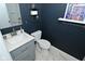 Cozy bathroom featuring a modern vanity, toilet, and shower with a stylish, dark blue accent wall at 1741 Terrace Ct, Franklin, IN 46131