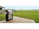 Spacious backyard with a grill on the concrete patio and a view of an open green space at 1862 Downey Ln, Greenfield, IN 46140