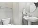 Modern powder room with a stylish pedestal sink, round mirror, and neutral color scheme at 1862 Downey Ln, Greenfield, IN 46140