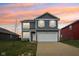 Charming two-story home with gray siding, white trim, attached two-car garage, and a vibrant sunset at 1862 Downey Ln, Greenfield, IN 46140
