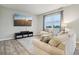 Comfortable living room with plush sofa, entertainment center, large window, and light wood floors at 1862 Downey Ln, Greenfield, IN 46140