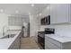 A well-lit, modern kitchen featuring stainless steel appliances and light gray cabinets at 18745 Moray St, Westfield, IN 46074