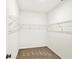 Bright, walk-in closet features wire shelving and neutral carpeting for ample storage in a modern home at 19113 River Jordan Pass, Westfield, IN 46074
