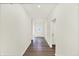 Bright hallway with hardwood floors and white walls leading to a glass-paneled door at 19113 River Jordan Pass, Westfield, IN 46074