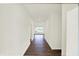 Hallway with wood floors and white walls leading to a window-filled room at 19113 River Jordan Pass, Westfield, IN 46074