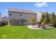 View of the home's backyard featuring a stone patio area and well-maintained lawn at 19546 Forsythe Dr, Noblesville, IN 46060