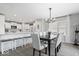 A bright dining area with an open view into the modern kitchen features a stylish chandelier and backyard access at 19546 Forsythe Dr, Noblesville, IN 46060