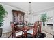 Bright dining room with a classic chandelier, hardwood floors and a dark wood china cabinet at 19546 Forsythe Dr, Noblesville, IN 46060