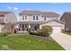 Charming two-story home boasts a manicured lawn, covered porch and attached two-car garage at 19546 Forsythe Dr, Noblesville, IN 46060