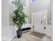Bright foyer with hardwood floors, large potted plant and a decorative bench at 19546 Forsythe Dr, Noblesville, IN 46060