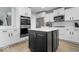 The updated kitchen is equipped with stainless steel appliances, an island, and sleek white cabinetry at 19546 Forsythe Dr, Noblesville, IN 46060