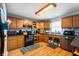 Functional kitchen includes wood cabinets, black appliances, laminate countertops and wood-look flooring at 20892 Overdorf Rd, Noblesville, IN 46062