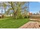 Lush green backyard featuring a large willow tree and a wooden deck at 24 W Pine Ridge Dr, Westfield, IN 46074