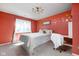 Bright bedroom with salmon-colored walls, plush white bedding, and stylish decor at 253 Provincial Ln # Apt D, Avon, IN 46123