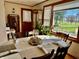 Sunlit dining area showcases a round table set for a meal, with a large window overlooking the greenery at 2575 S Indianapolis Rd, Lebanon, IN 46052