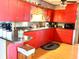 The eat-in kitchen features red cabinets, a stainless sink, and laminate wood flooring at 2575 S Indianapolis Rd, Lebanon, IN 46052