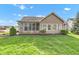 Well-manicured backyard featuring a screened porch, lush lawn, and beautiful landscaping at 2601 Viceroy Ln, Lebanon, IN 46052