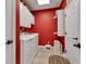 Bright laundry room with red accent wall, white cabinets and modern washer and dryer units at 2601 Viceroy Ln, Lebanon, IN 46052