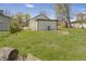 Backyard featuring a storage shed, lush green lawn, and mature trees at 2631 Collier St, Indianapolis, IN 46241