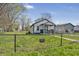 Exterior view of fenced yard with warning sign; clear blue sky, healthy trees at 2631 Collier St, Indianapolis, IN 46241