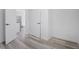Hallway featuring modern vinyl floors, white walls, and white doors at 2631 Collier St, Indianapolis, IN 46241