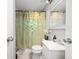 Cozy bathroom featuring a shower with patterned curtain, a toilet and sink with a decorative mirror at 3021 Midvale Dr, Indianapolis, IN 46222