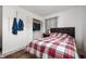 View of a bedroom with a plaid comforter, closet, dark headboard and light walls at 3021 Midvale Dr, Indianapolis, IN 46222