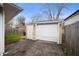 A detached garage is pictured behind a home with a driveway and wooden fencing at 3021 Midvale Dr, Indianapolis, IN 46222
