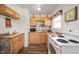 Efficient kitchen featuring wood cabinets, a backsplash, appliances, and vinyl flooring at 3021 Midvale Dr, Indianapolis, IN 46222