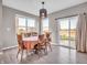 Dining area with wooden table, chairs, modern pendant light, and a sliding glass door to the backyard patio at 3053 Creekridge Ct, Columbus, IN 47201