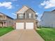 Two-story home featuring a two-car garage, brick accents, and a well-maintained lawn at 3053 Creekridge Ct, Columbus, IN 47201