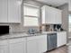 Modern kitchen featuring white cabinets, granite countertops, a stainless steel sink, and a bright window at 3053 Creekridge Ct, Columbus, IN 47201