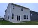 Rear exterior view of a two-story home with sliding glass doors opening onto a small patio at 3078 Creekridge Ct, Columbus, IN 47201