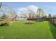 A lush backyard with a fire pit, trampoline, and wooden fencing at 3414 Arbor Ave, Indianapolis, IN 46217
