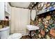 Compact bathroom featuring a modern sink, patterned wallpaper, and a shower with curtain at 3414 Arbor Ave, Indianapolis, IN 46217