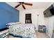A cozy bedroom features a floral comforter, ceiling fan, and a wall-mounted television at 3414 Arbor Ave, Indianapolis, IN 46217