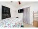 A cozy bedroom features a floral comforter, mounted television, and natural light at 3414 Arbor Ave, Indianapolis, IN 46217