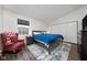 Cozy bedroom features a queen-size bed with blue comforter, an accent chair, and a double-door closet at 3624 N Lakeside Dr, Muncie, IN 47304