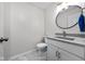 Stylish powder room with a granite countertop, a modern mirror, and gray tile flooring at 3624 N Lakeside Dr, Muncie, IN 47304